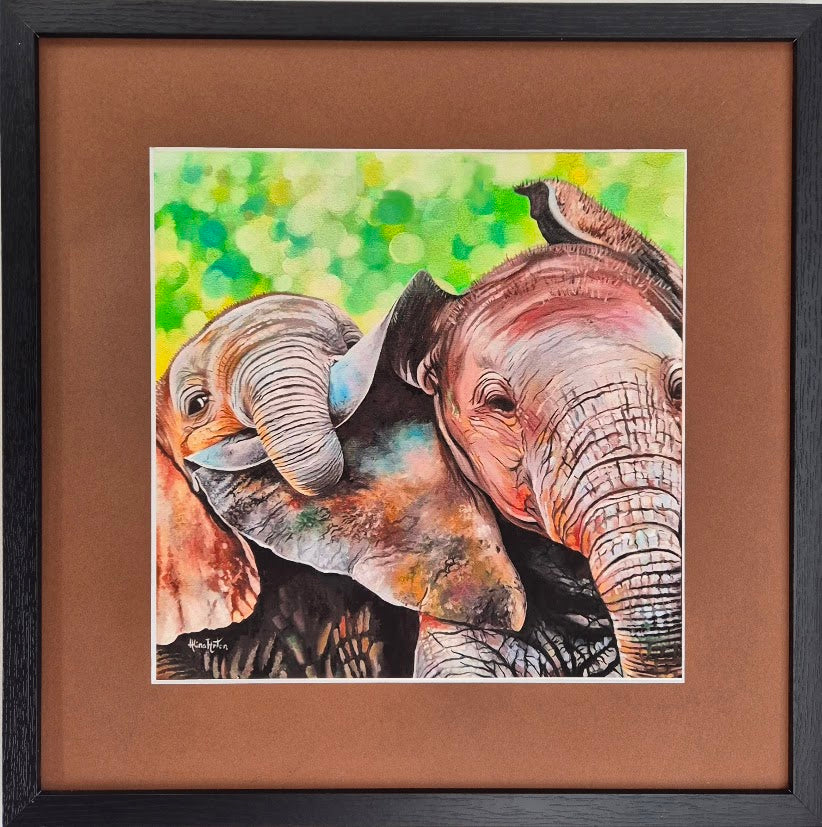 Fine art print of two playful elephants with little elephant clinging to the other's ear, framed with brown mount